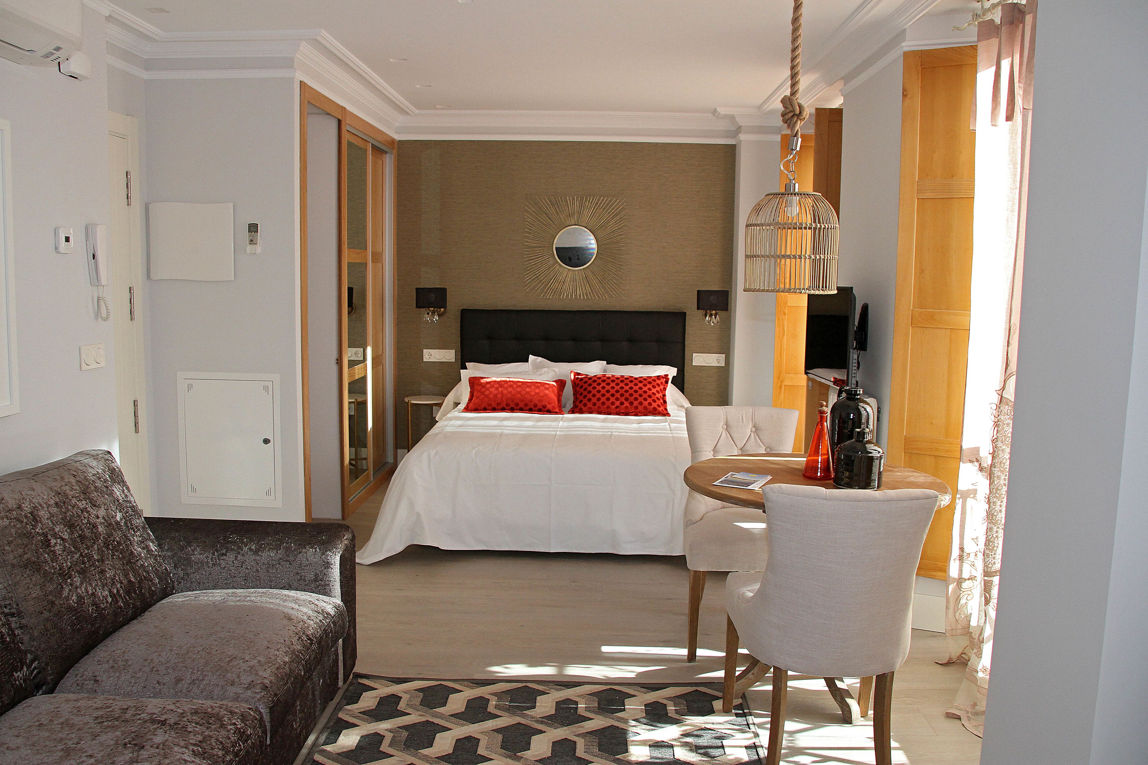 Una habitación de hotel con una cama, un sofá, una mesa de comedor y una silla.