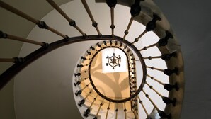 Un escalier en colimaçon orné d’un emblème central.