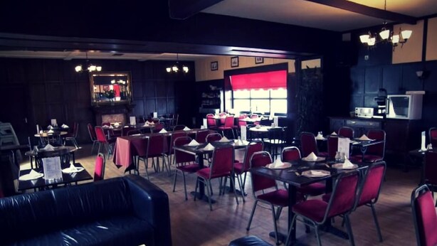 A restaurant with multiple dining tables and chairs, a bar area, and a seating area with couches. - The Elbow Room (Kirkcaldy)