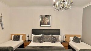 A double room with a large bed, two bedside tables, a chandelier, and a framed picture on the wall. - The Elbow Room (Kirkcaldy)