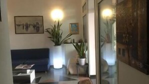 Eine moderne Lobby mit einem blauen Sofa, Topfpflanzen und Kunstwerken an den Wänden.