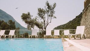 A pool with white lounge chairs and a view of a mountain. - 7 Green Adrasan (Kumluca)