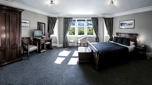 A bedroom with a large bed, a desk with a computer, a chair, and a wardrobe. - Invergarry Hotel (Invergarry)