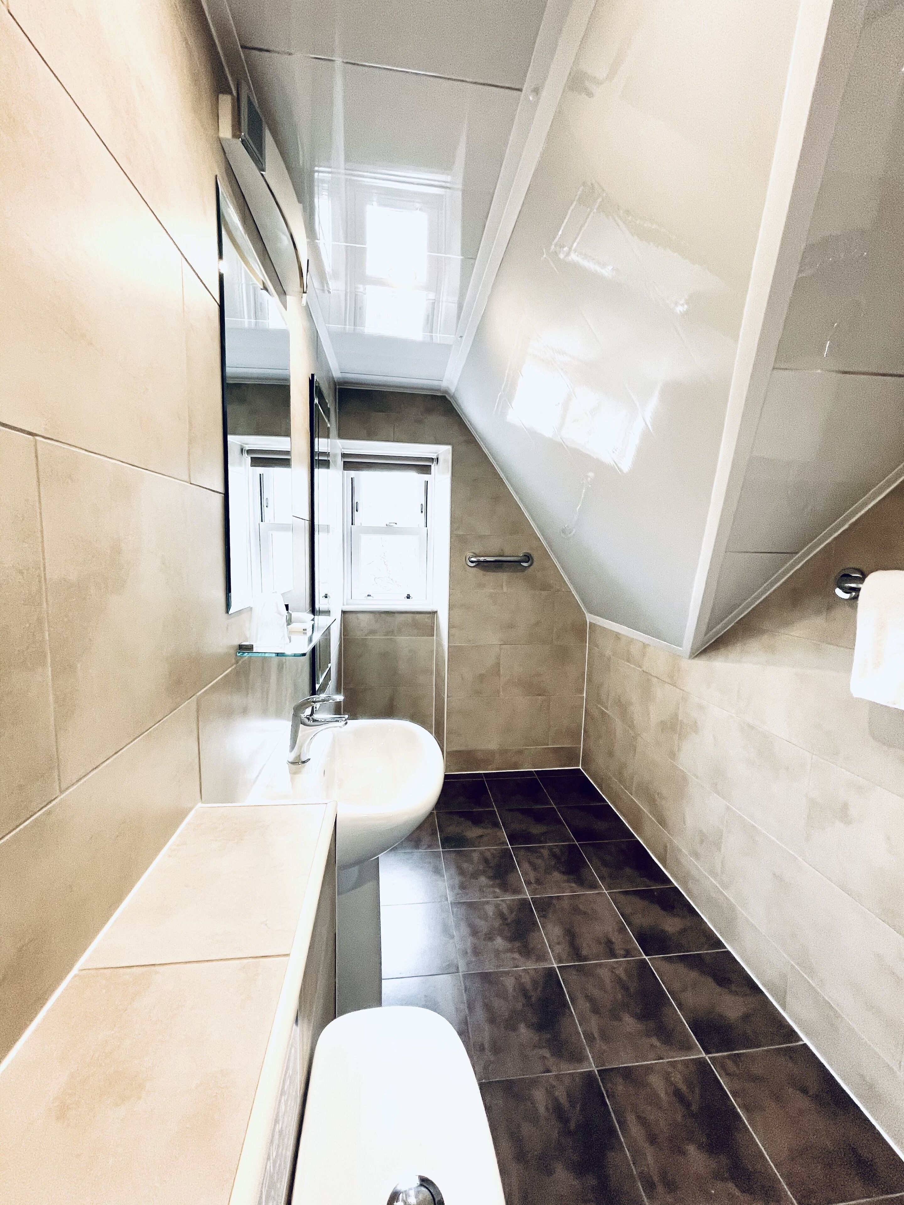 Une salle de bain moderne équipée de toilettes, d’un lavabo et d’un espace douche.