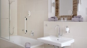 A modern bathroom with a bathtub, a sink, and a mirror. - Haus Am Fluss (Laurenburg)