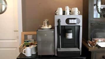 Een koffieapparaat met melkopschuimer en koffiezetdispenser op een keukenblad.