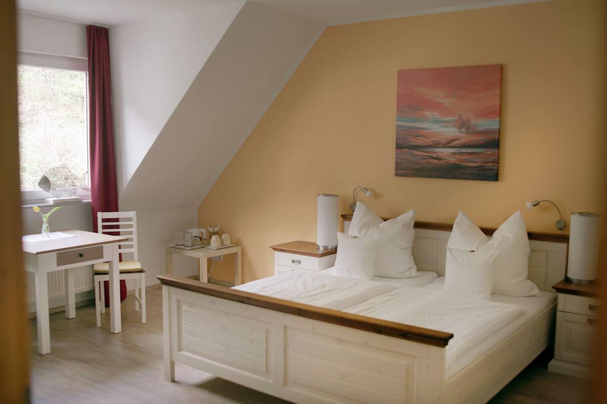 Ein Schlafzimmer mit einem Bett, Nachttischen, einem Schreibtisch und einem Stuhl.