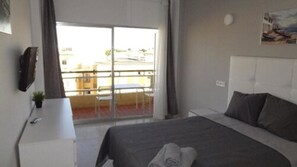 Escritorio, cortinas blackout y tabla de planchar con plancha