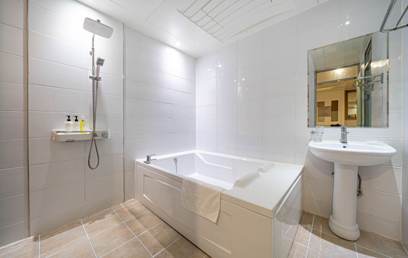 A modern bathroom with a bathtub, a shower, and a sink.