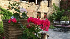 A courtyard with potted plants and a metal bench. - Varosi 4 Seasons (Edessa)