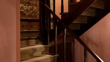 Una escalera con barandillas de madera y peldaños alfombrados.