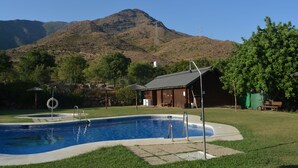 A swimming pool with a mountain in the background. - Bungalows Los Pedregales (Estepona)