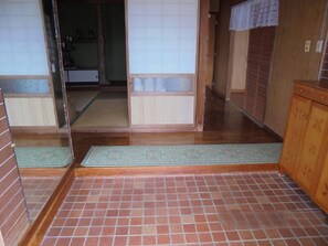 Un interior japonés tradicional con suelo de tatami, puertas correderas y armarios de madera.