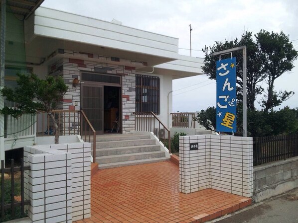 Un edificio con entrada de baldosas y un letrero azul con caracteres japoneses.