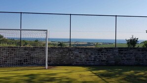 A soccer goal with a stone wall behind it, set against a backdrop of a clear sky and distant landscape. - Villa Giardino degli Eventi (Fano)