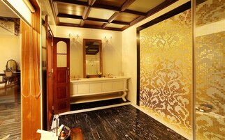 Un baño con tocador, espejo y paredes de azulejos.