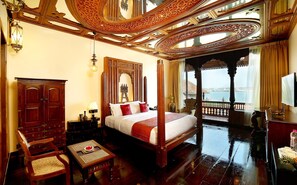 A spacious bedroom with a four-poster bed, wooden furniture, and a balcony with a view of the sea. - Ginger House Museum Hotel (Kochi)