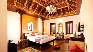 A spacious bedroom with a large bed, a chandelier, and a wooden ceiling. - Ginger House Museum Hotel (Kochi)