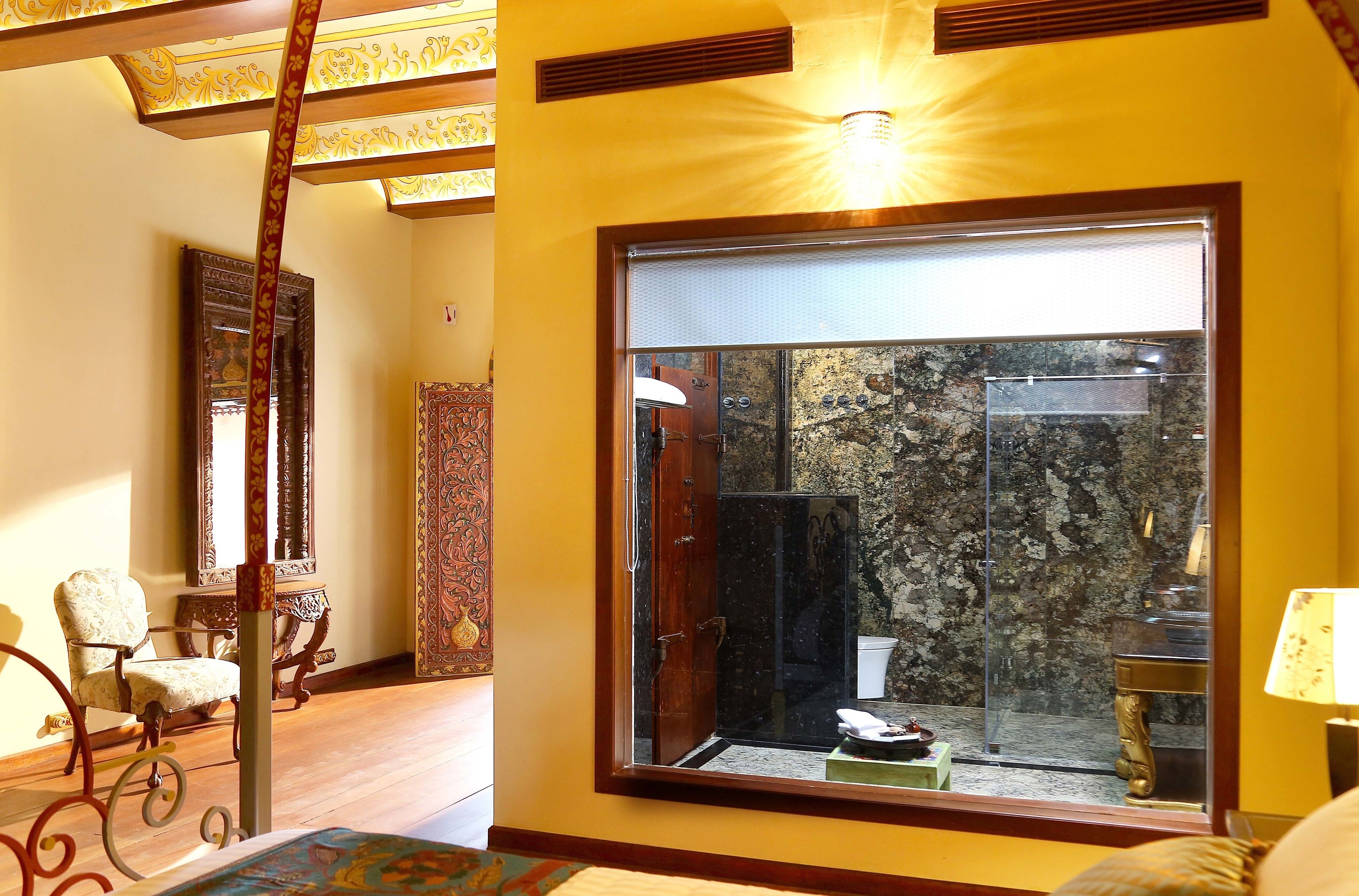 A room with a large window, wooden furniture, and a decorative ceiling.