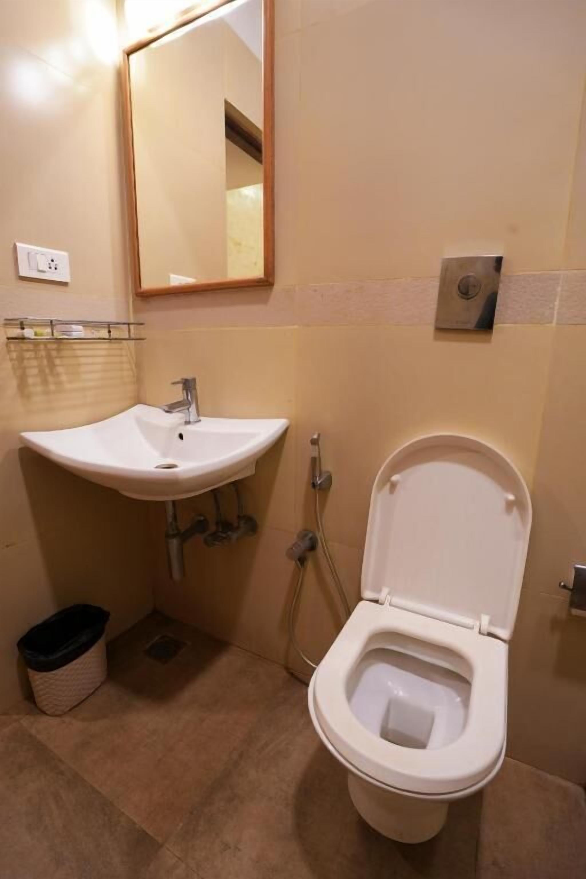 A bathroom with a white sink, a toilet, and a mirror.