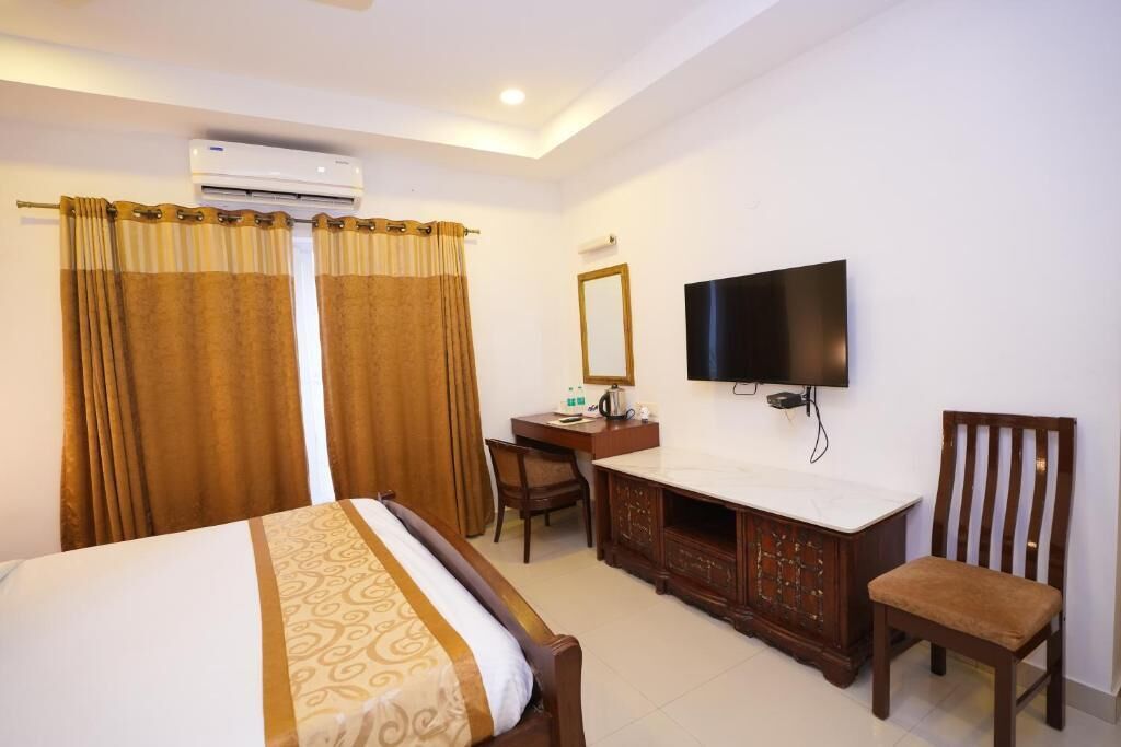 Une chambre d’hôtel équipée d’un lit, d’un bureau avec une chaise, d’une télévision et d’un appareil de climatisation.