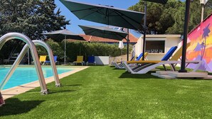 Un espace piscine offrant une vue dégagée sur la piscine, avec des chaises longues et des parasols.