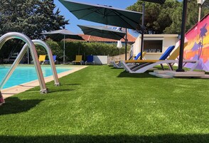 Una piscina al aire libre, sillones reclinables de piscina