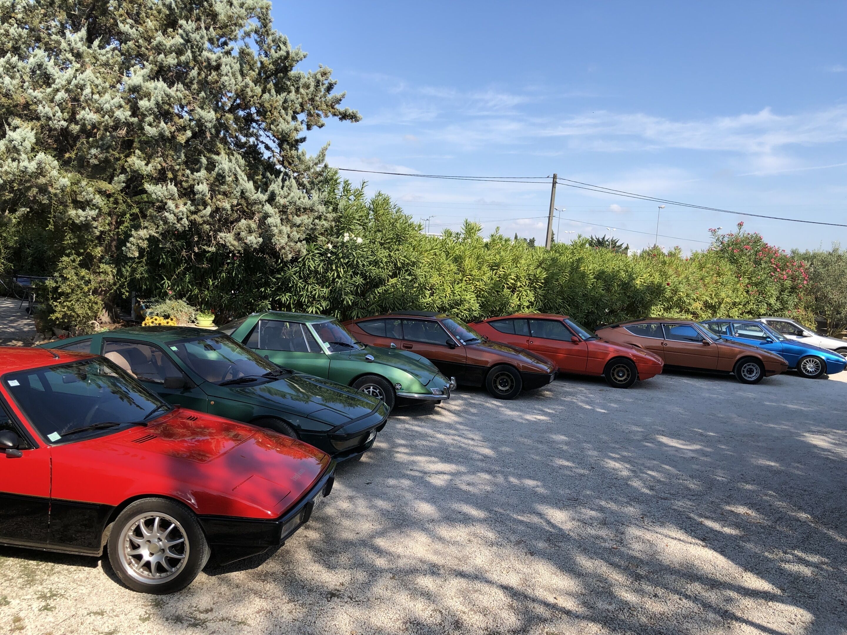 Een parkeerplaats met meerdere oldtimers op een rij.