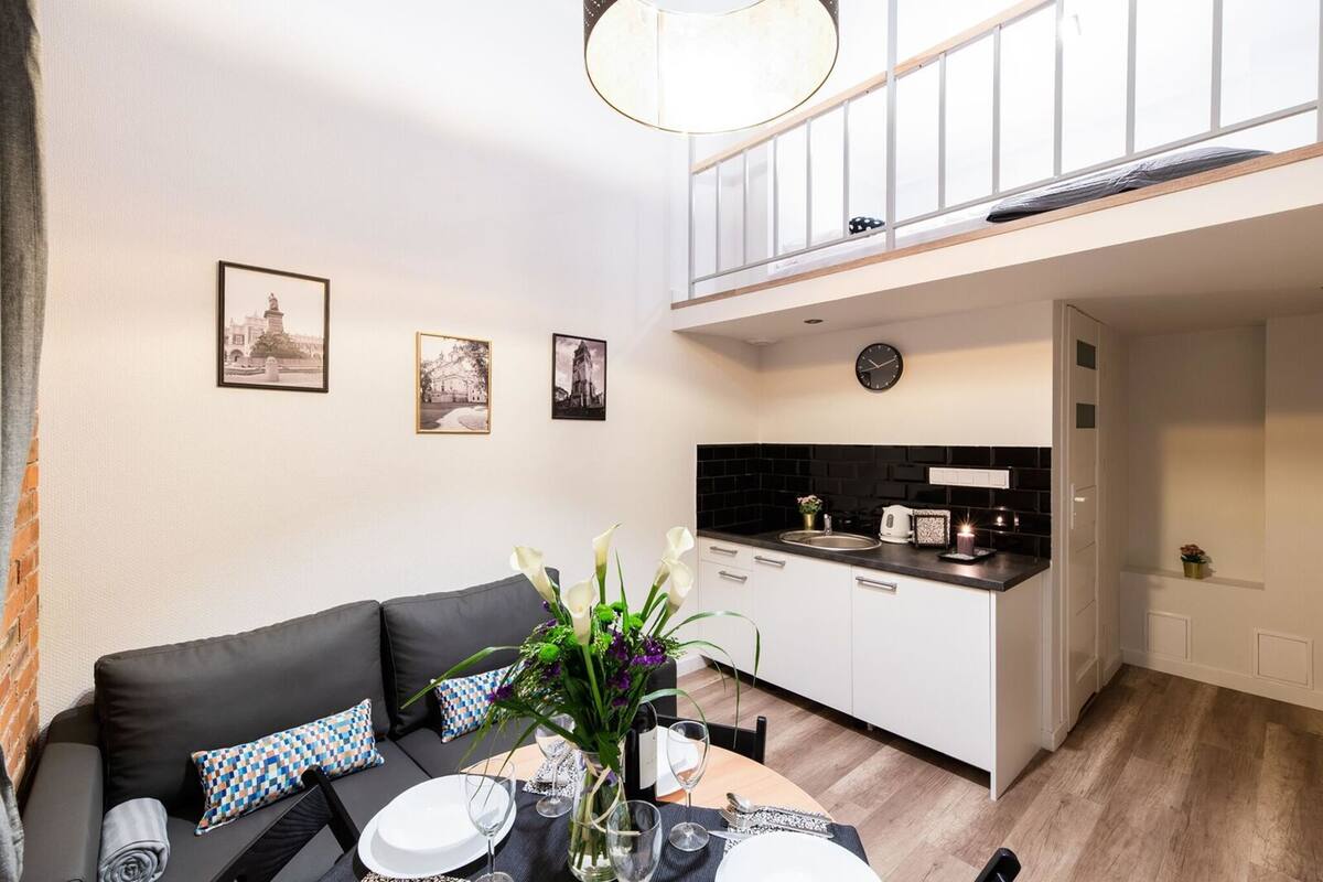 A modern apartment with a dining area, a kitchen, and a balcony.