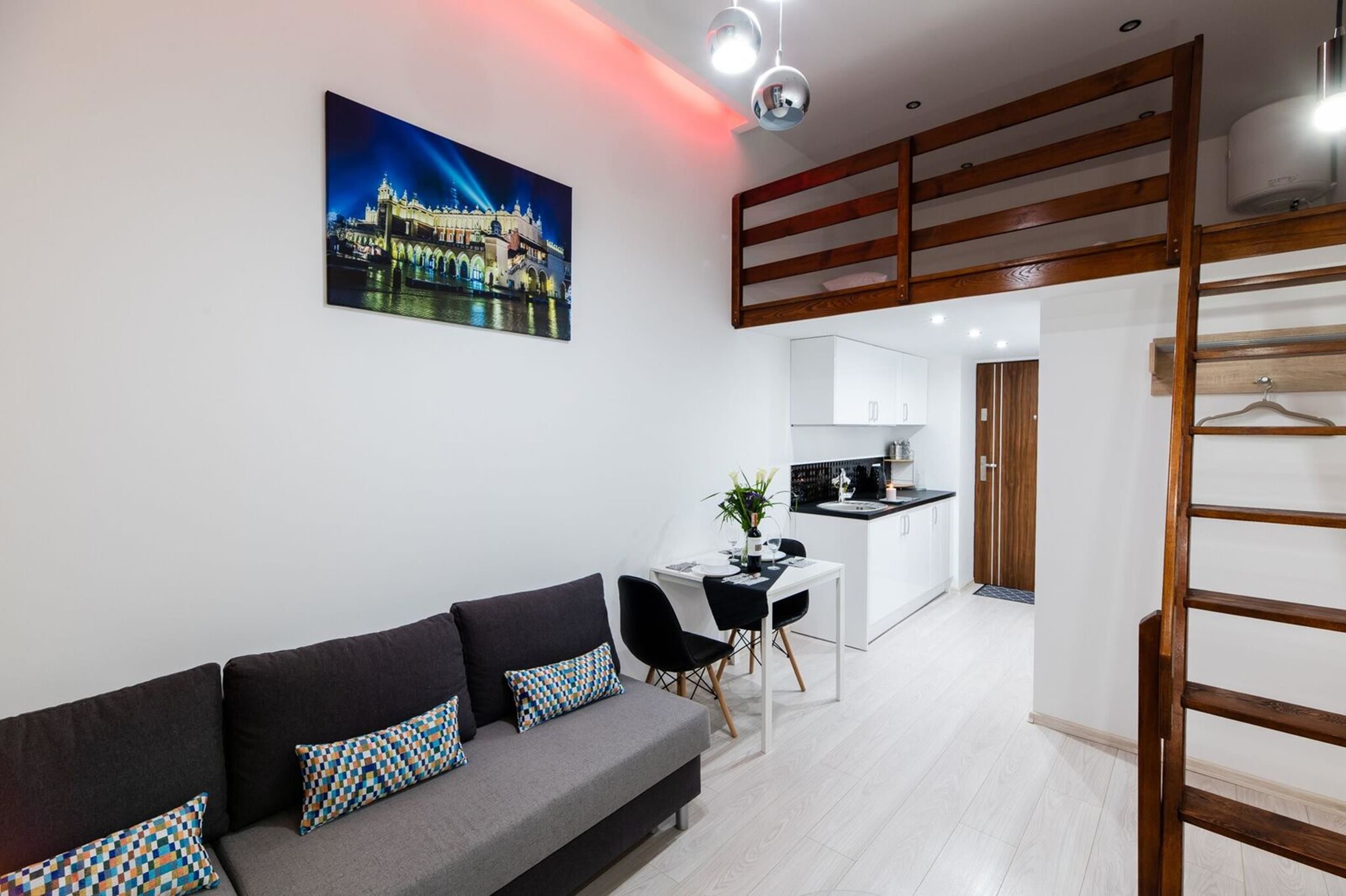 Una sala moderna con un sofá, una mesa de comedor y una cocina al fondo.