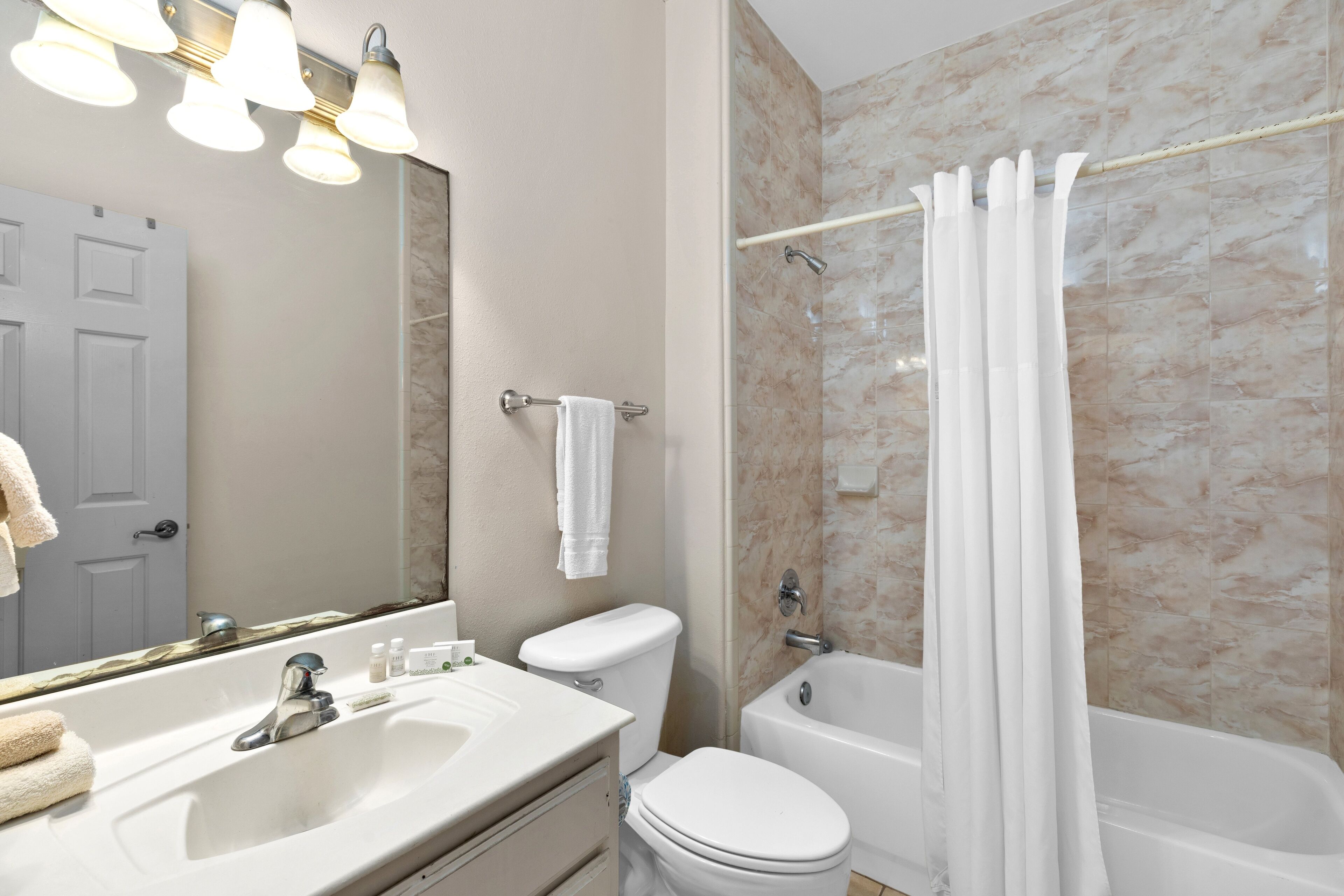 A bathroom with a sink, toilet, and bathtub.