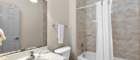 A bathroom with a sink, toilet, and bathtub.