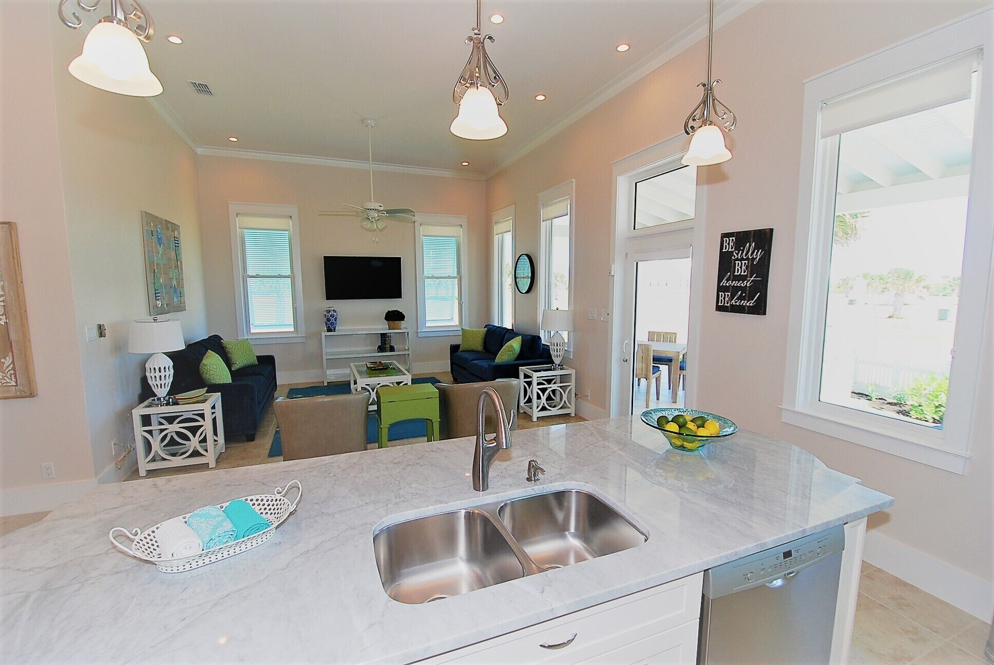 A modern kitchen with a built-in dishwasher, a sink, and a dining area with a table and chairs.