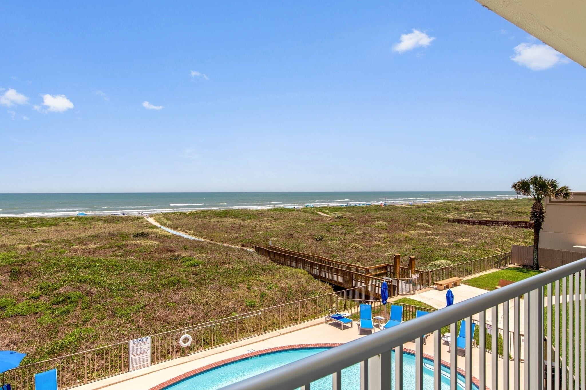 A pool with a view of the beach and ocean.
