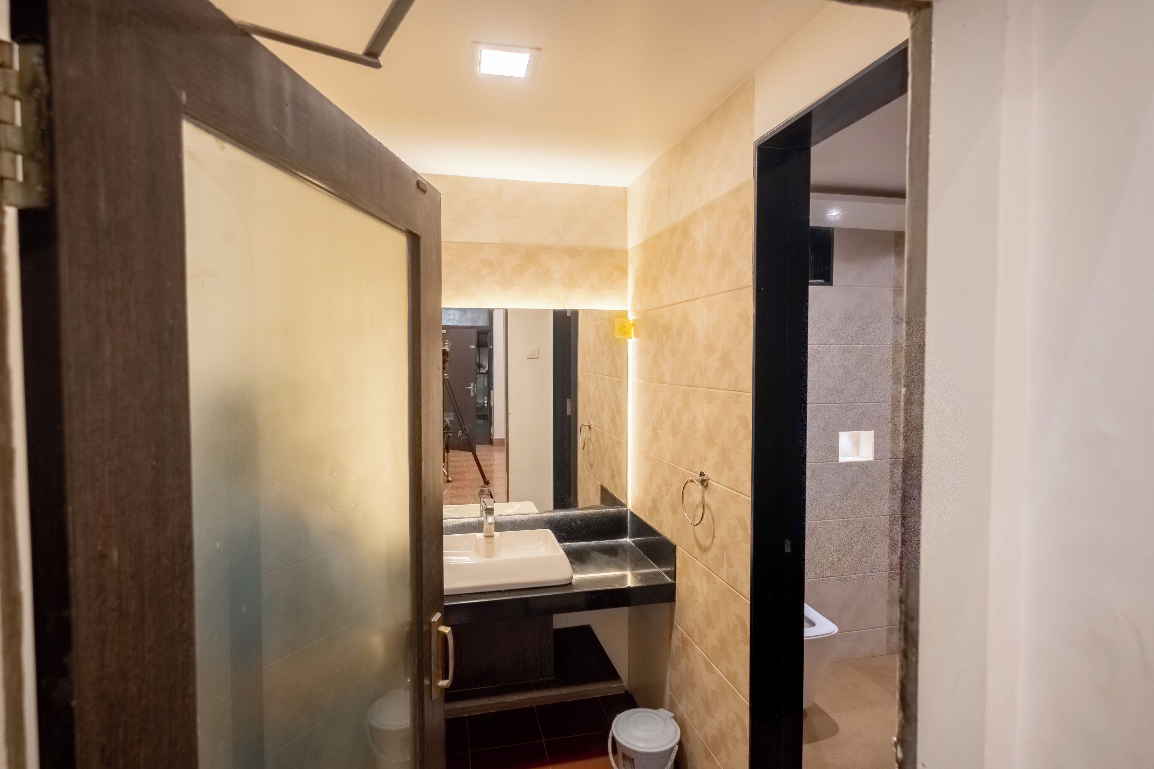 Une salle de bain moderne avec un lavabo, un miroir et des toilettes.