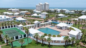 A resort with multiple buildings, a tennis court, a swimming pool, and a view of the ocean. - Paradise Found - Private Beachfront House 3 Bedroom Home by RedAwning (South Padre Island)