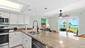 A kitchen with white cabinets, a granite countertop, a dishwasher, a microwave, and a sink. - Beach House Unit #302 2 Bedroom Condo by RedAwning (South Padre Island)