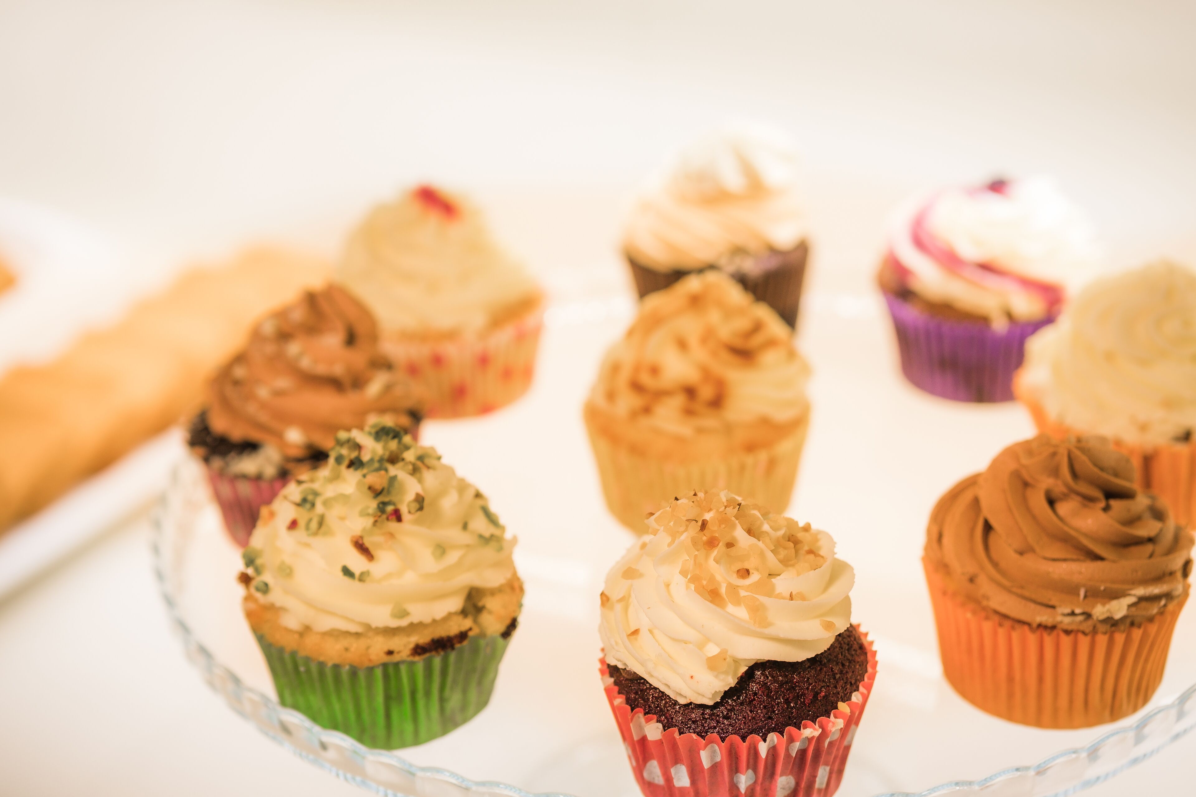 A variety of cupcakes on a glass plate.