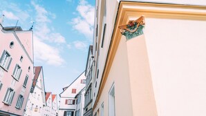 Una calle estrecha flanqueada por edificios con arquitectura europea tradicional y un cielo despejado.