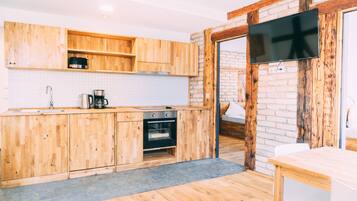 Een moderne keuken met houten kastjes, een inbouwoven en een groot raam.