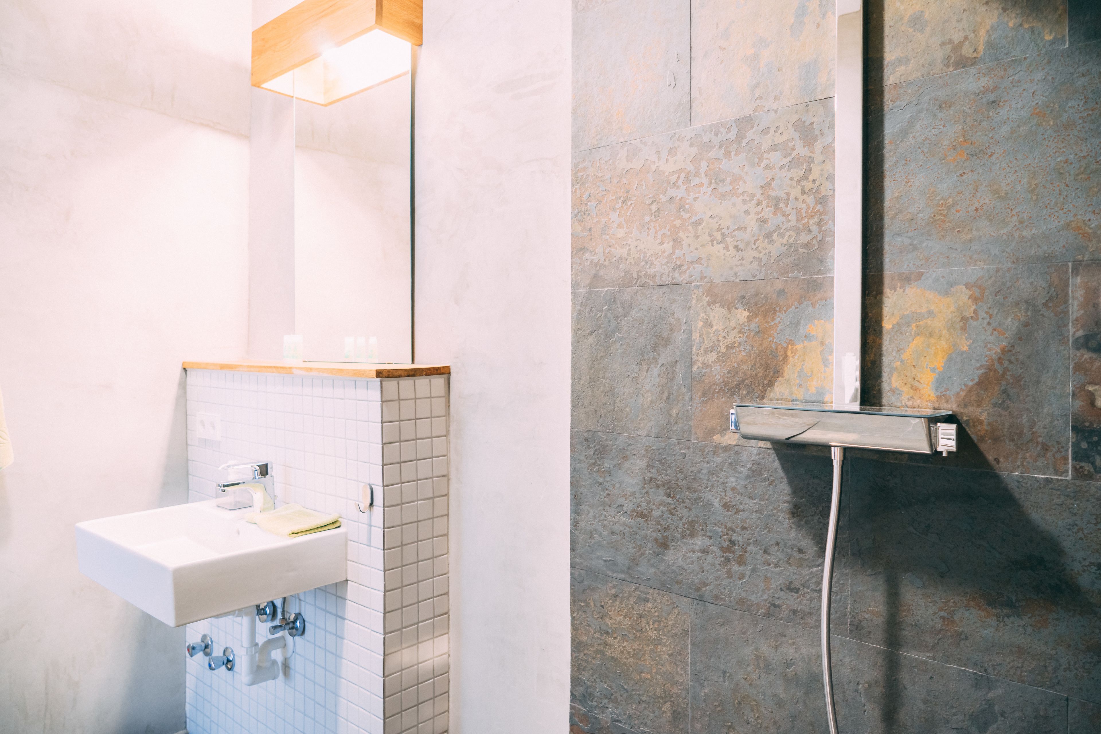 A bathroom with a white sink, a mirror, and a shower area with a glass enclosure.