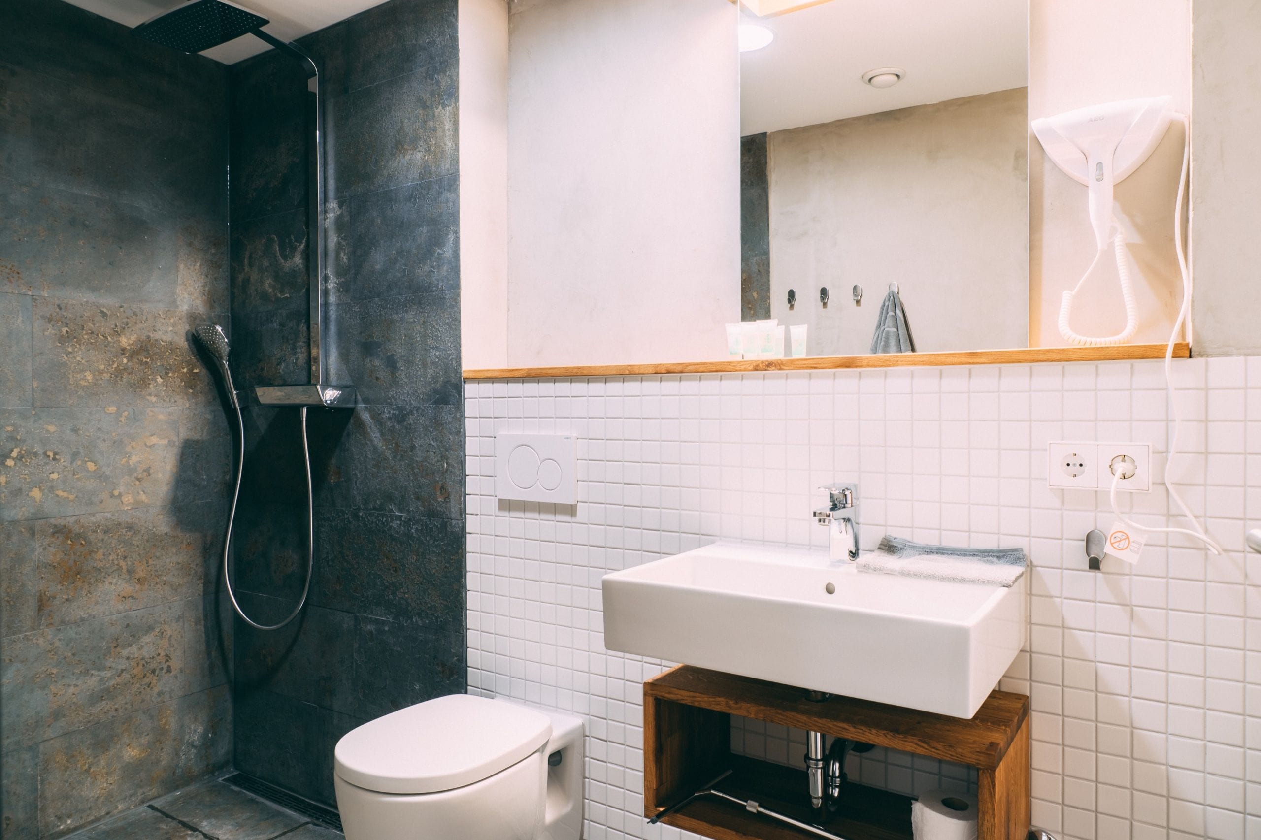 A modern bathroom with a shower, toilet, and sink.