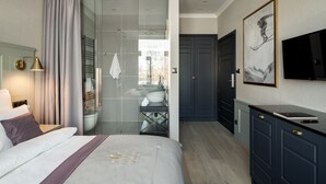 A modern hotel room with a bed, a desk, a TV, and a wardrobe. - Krupówki 17 Resort & Spa (Zakopane)