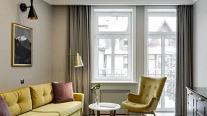 A modern living room with a yellow sofa, a round table, and a vintage armchair. - Krupówki 17 Resort & Spa (Zakopane)