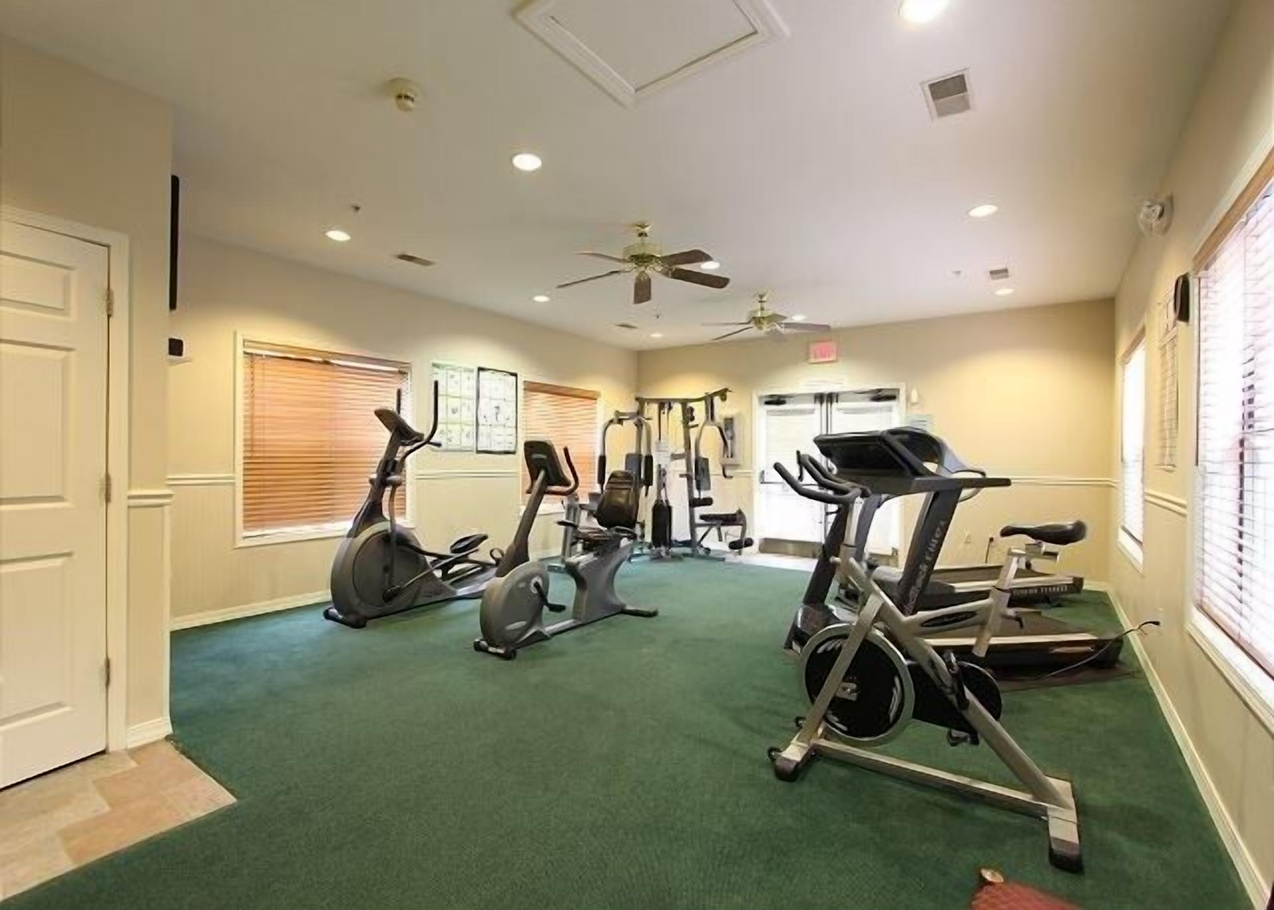 A fitness center with treadmills, stationary bikes, and weight machines.