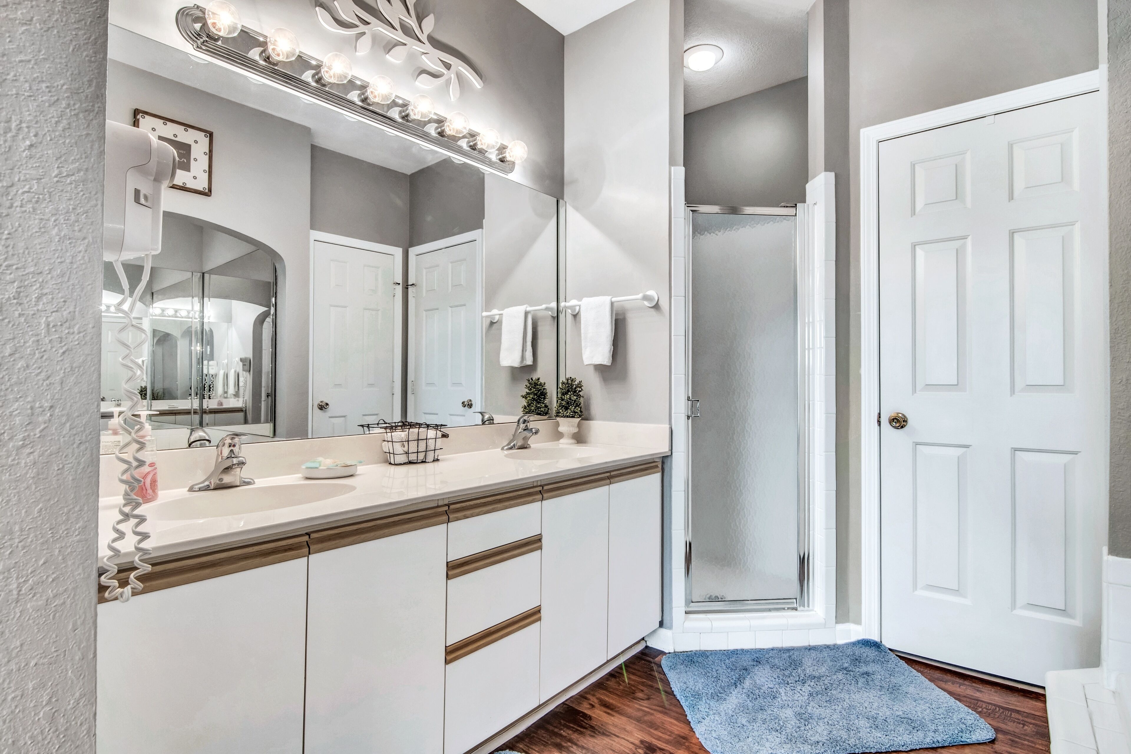 Une salle de bain équipée d’un meuble-lavabo, d’un miroir, d’un porte-serviettes et d’un espace douche.