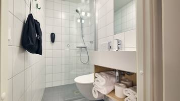 Un baño moderno con inodoro, ducha y lavamanos.