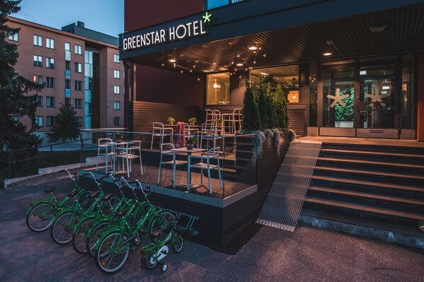 The exterior of the GreenStar Hotel with outdoor seating and bicycles.