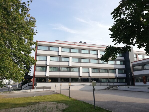 Un edificio de varios pisos con techo plano, ventanas amplias y una entrada central.