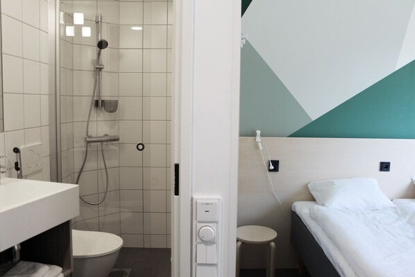 A hotel room with a shower, toilet, and bed. - GreenStar Hotel Jyväskylä (Jyväskylä)